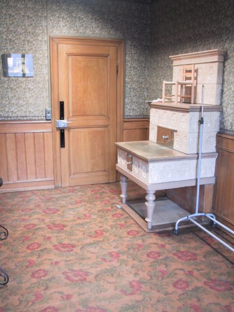 Zimmer im 1.OG mit originalem Kachelofen, Inlaidlinoleum und Tapeten, Foto Tauss